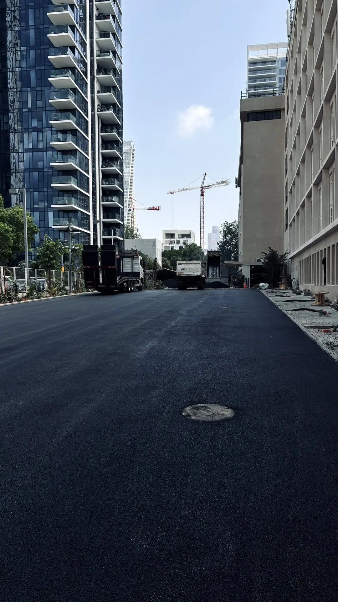 החניון לאחר הסלילה — משטח האספלט החדש בין המבנים